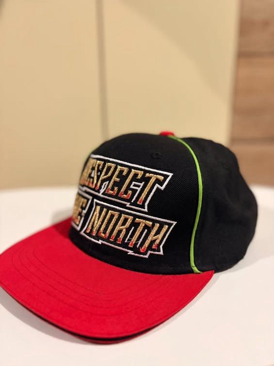Mitchell & Ness Respect The North Snapback Cap (Category: Vintage Collectibles) located in Cebu City. Submitted by ubecstoned (Listing ID 1468825266, Image 2). Description: - Brand: Mitchell & Ness - Style: Snapback hat with flat brim - Colors: Black crown, red flat brim, and neon green piping - Embroidery: "Respect The North" in gold and white with red outlines on the front - Closure: Adjustable snapback - Authenticity: Official branding tag sti