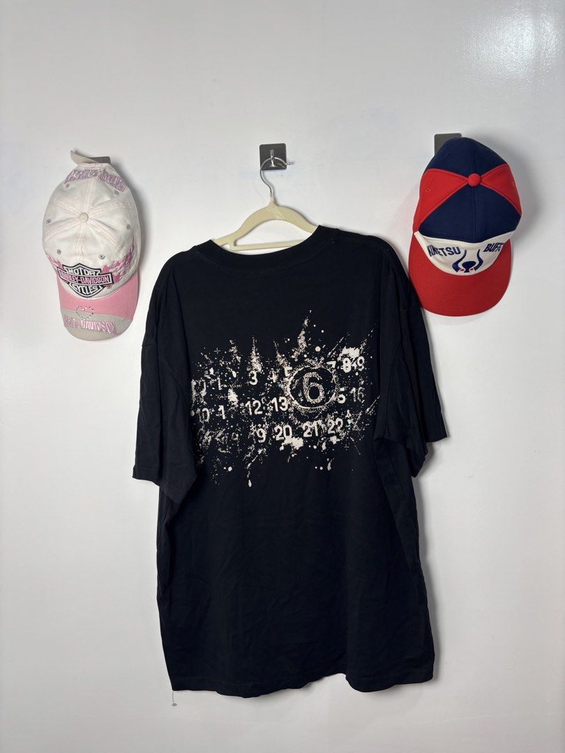 MM6 Maison Margiela Number Graphic Black Tee (Category: Shirts) located in Calbayog City. Submitted by zaxcheus_castillo1708 (Listing ID 1468754844, Image 2). Description: - Brand: MM6 Maison Margiela - Color: Black - Fit: Relaxed fit with a crew neckline and straight hem - Material: Standard cotton jersey fabric - Design details: Small metallic distressed logo on front left chest; large distressed number graphic and trendy paint splatter effect 