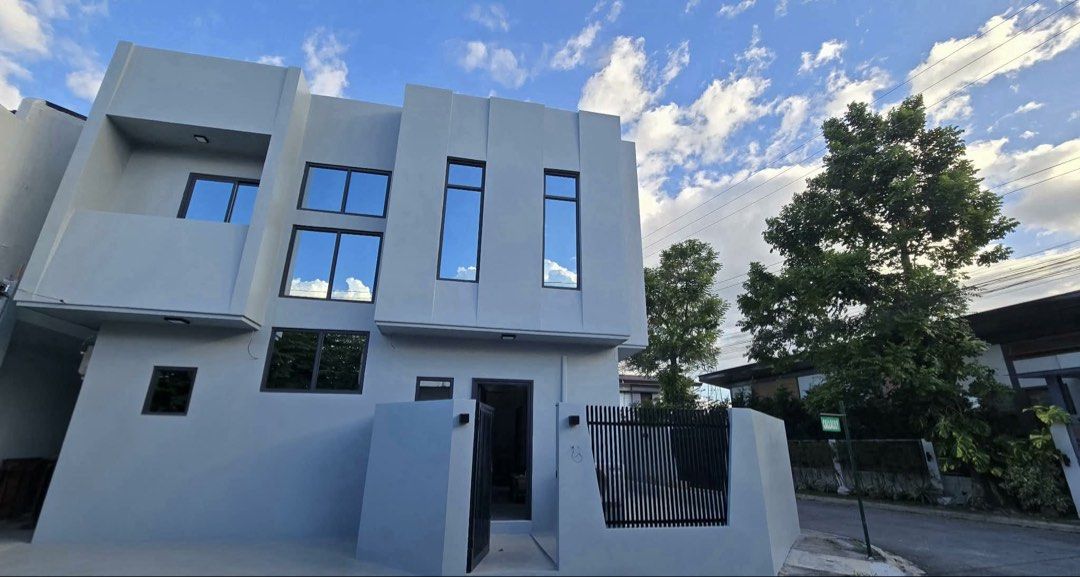FOR SALE: MODERN MINIMALIST HOUSE and LOT (Category: Bed Frames & Mattresses) located in Angeles City. Submitted by tatasexy_24 (Listing ID 1468517973, Image 1). Description: - Style: Clean minimalist design in neutral gray tones with abundant natural light - Bedroom: Includes a spacious gray bed frame, matching sectional sofa, and sleek concrete-look flooring - Windows: Fitted with modern roller blinds - Bathroom: Features a luxurious freestandi