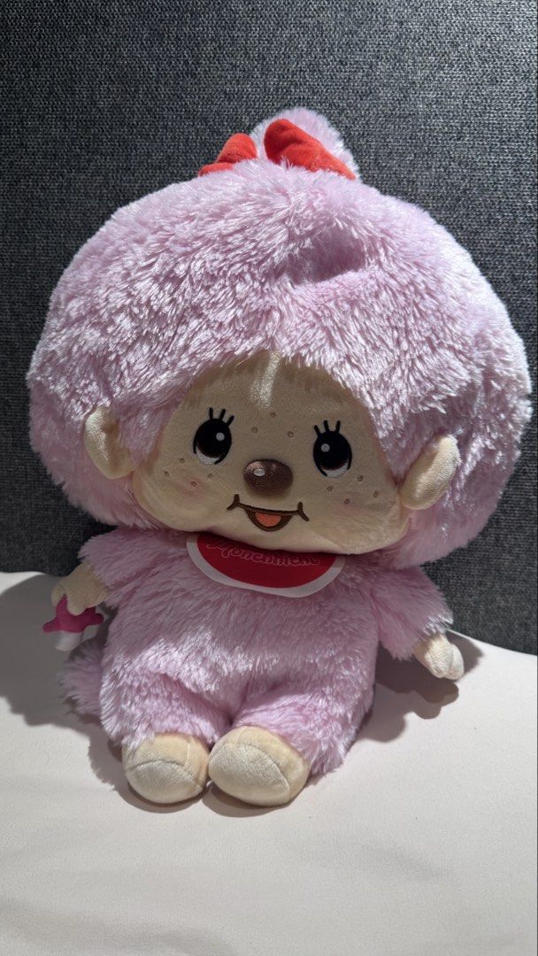 Monchhichi Pink Plush Doll with Pacifier and Bib (Category: Plushies & Soft Toys) located in Mandaluyong City. Submitted by maelovestoshop (Listing ID 1468882701, Image 1). Description: - Authentic pink Monchhichi plush doll by Sekiguchi - Super soft furry texture with a cute face, freckles, and sticking-out tongue - Wears a classic red bib with white trim and a matching red hair bow - Holds a detachable pink pacifier in its right hand - Official