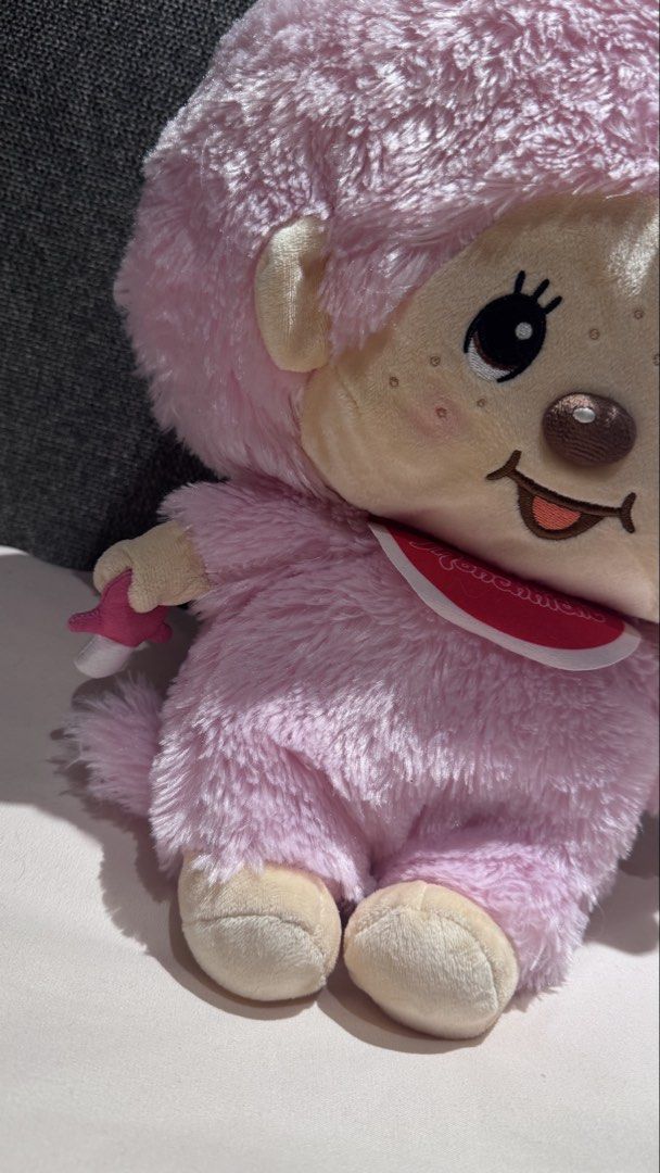 Monchhichi Pink Plush Doll with Pacifier and Bib (Category: Plushies & Soft Toys) located in Mandaluyong City. Submitted by maelovestoshop (Listing ID 1468882701, Image 2). Description: - Authentic pink Monchhichi plush doll by Sekiguchi - Super soft furry texture with a cute face, freckles, and sticking-out tongue - Wears a classic red bib with white trim and a matching red hair bow - Holds a detachable pink pacifier in its right hand - Official
