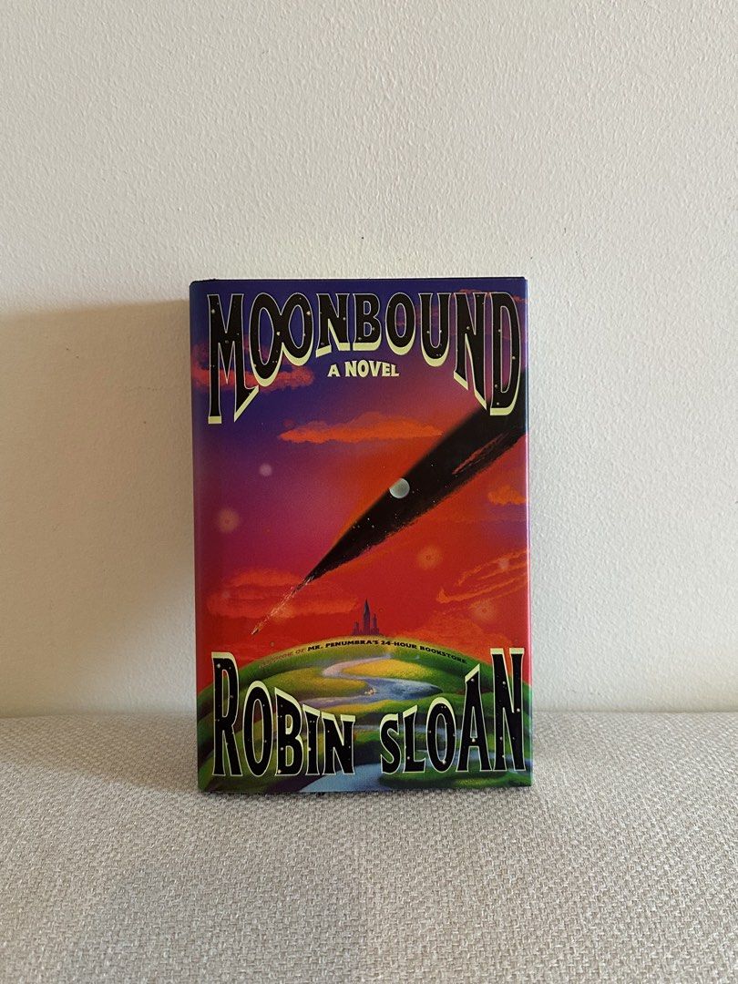 Moonbound by Robin Sloan Hardcover Novel (Category: Storybooks) located in Pasig City. Submitted by cosmicjuice08 (Listing ID 1468737856, Image 1). Description: - Title: Moonbound by Robin Sloan - Edition: Hardcover with vibrant celestial dust jacket - Series: Part of the Penumbraverse - Condition: Pristine white pages inside, never read - Source: Bought locally from Fully Booked (original price sticker on back cover) - Genre: Great addition for 