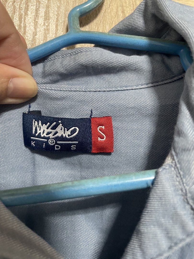 Mossimo Kids Size S Blue Button-Down dress (Category: Babies & Kids Fashion) located in Bulacan. Submitted by PrelovedHub12 (Listing ID 1468813680, Image 2). Description: - Brand: Mossimo Kids - Color: Solid Blue - Size: S (tag on collar) - Design: Classic collared neckline with dark brown front buttons - Sleeves: Long sleeves with button cuffs - Style: Casual - Condition: Clean fabric with standard textured weave.
