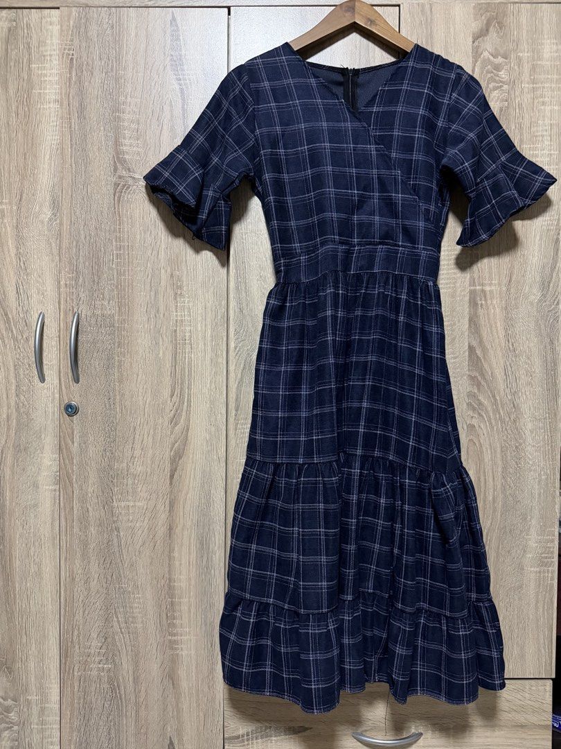 Navy Blue Plaid Midi Dress (Category: Dresses) located in Bulacan. Submitted by relove.re (Listing ID 1468719961, Image 1). Description: Elegant and classy with a timeless plaid pattern! 💙 Size: XS to S ✔️ Navy blue with white checkered design ✔️ Flattering V-neckline ✔️ Stylish flutter sleeves ✔️ Defined waist for a feminine silhouette ✔️ Tiered skirt for a flowy, graceful look ✔️ Back zipper closure Perfect for casual outings, office wear, chu