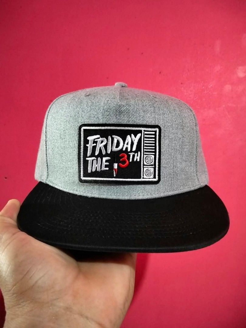 Navy Co. Friday The 13th Snapback Cap (Category: Caps & Hats) located in Mangaldan. Submitted by niftythrifty69 (Listing ID 1468734233, Image 1). Description: - Brand: Navy Co. - Design: Grey and black snapback with embroidered Friday The 13th patch and red 3 - Material: 100% cotton - Fit: Adjustable plastic strap at the back - Condition: Structured crown with a clean interior sweatband - Perfect for horror movie fans and everyday streetwear.