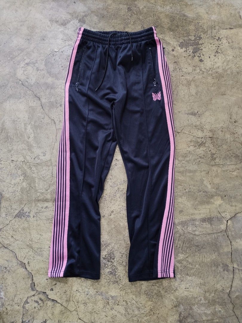 Needles Track Pants Black Pink Size S (Category: Joggers) located in Pasig City. Submitted by loveforlux_2025 (Listing ID 1468784477, Image 1). Description: - Brand: Needles (Nepenthes) - Color: Black with pink side stripes - Size: Small - Details: Embroidered butterfly logo on left thigh, elastic drawstring waistband, and zippered side pockets - Material: 100% Polyester - Origin: Made in Japan - Condition: Clean overall, style code IN933.