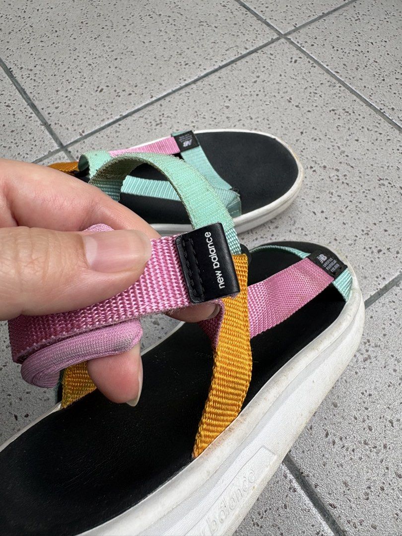 New Balance Multicolor Strappy Sandals (Category: Flats & Sandals) located in Paranaque City. Submitted by caityprecky (Listing ID 1468795739, Image 2). Description: - Brand: New Balance - Style: Pastel multicolored sandals (Pink, mint green, and yellow) - Closure: Adjustable velcro straps for a secure fit - Details: Black footbed with white midsole - Condition: Soles show dirt and wear from normal outdoor use - Best for: Casual everyday walking 