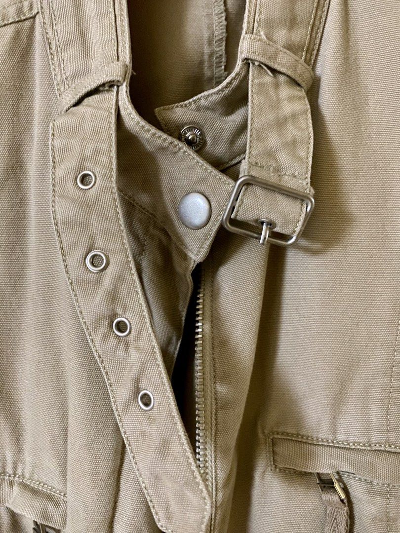 NEXT Khaki Utility Jacket Size UK 12 EUR 40 (Category: Coats, Jackets and Outerwear) located in Baguio. Submitted by vintagefox (Listing ID 1468808944, Image 3). Description: - Brand: NEXT - Size: UK 12 / EUR 40 - Color: Khaki - Material: Sturdy cotton canvas - Closure: Full zip with buckled high collar and metal eyelets - Pockets: Multiple front pockets with zippers and flaps - Detail: Subtle tonal floral embroidery on the left sleeve.