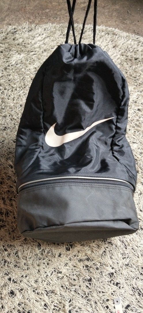 Nike Black Drawstring Gym Bag with Bottom Compartment (Category: Backpacks) located in Paranaque City. Submitted by michael-08 (Listing ID 1468750255, Image 3). Description: - Authentic black Nike drawstring backpack in excellent, clean condition - Features a large, stylish light-coloured Swoosh logo on the front - Handy separate zipped bottom compartment ideal for shoes or wet/dirty gear - Made from durable, lightweight nylon material with sturd