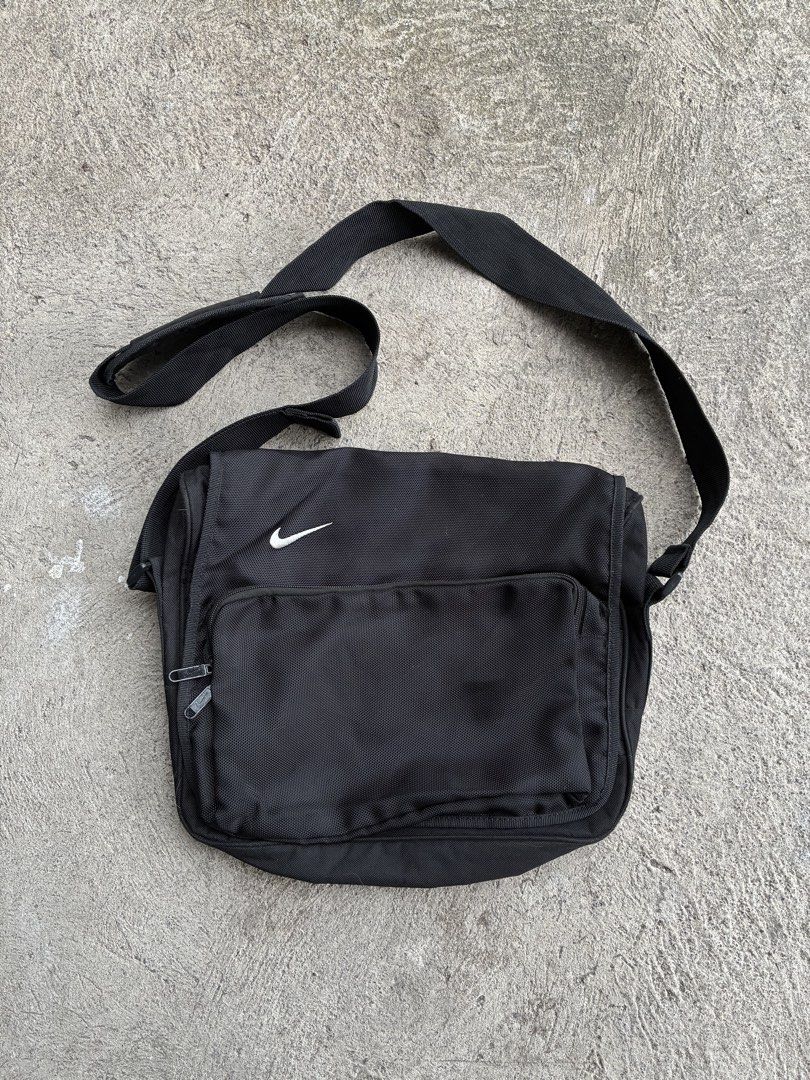 Nike Black Messenger Bag (Category: Sling Bags) located in General Santos City (Dadiangas). Submitted by sidequest666 (Listing ID 1468916069, Image 1). Description: - Authentic Black Nike messenger bag made with durable fabric - Features an adjustable strap for a comfortable, custom fit - Iconic embroidered white swoosh logo on the front flap - Exterior zip pocket for quick-access items - Spacious main compartment with inner zip pocket, pen slots