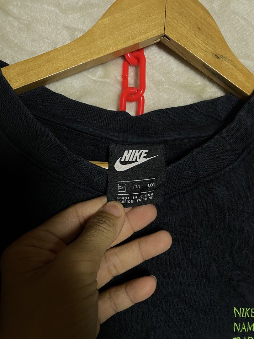 Nike Black Sweatshirt XXL (Category: Coats, Jackets and Outerwear) located in Molave. Submitted by charlesthrifter (Listing ID 1468861083, Image 2). Description: - Brand: Nike - Style/Model Code: DJ0466-010 (Made in China) - Size: XXL - Color: Black with neon green text and small pink embroidered cuff logo - Details: 'SWOOSH' lettering on right sleeve, Nike trademark info on left chest - Material: Thick fleece interior with ribbed collar, cuffs, 