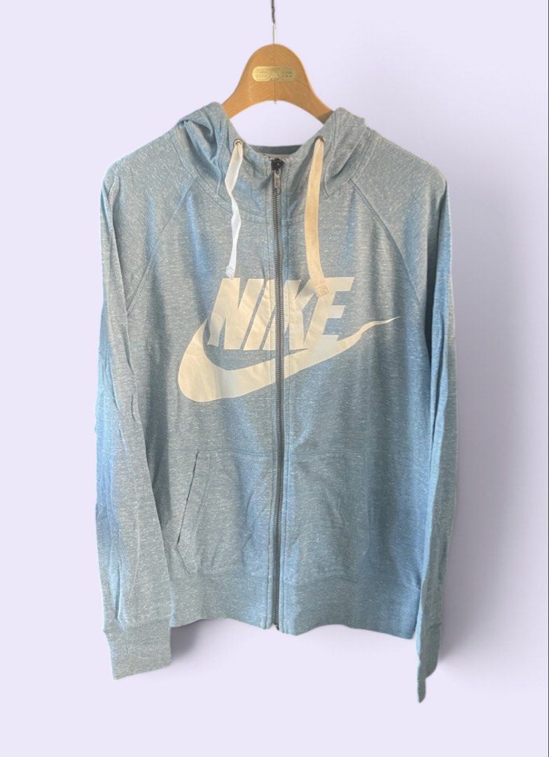 Nike Blue Zip Up Hoodie Unisex (Category: Coats, Jackets and Outerwear) located in San Pedro. Submitted by lifebeginsaftercoff33 (Listing ID 1468762995, Image 3). Description: - Brand: Nike - Color: Blue heathered - Size: M on tag - Dimes: 20 x 25 - Design: Large white logo graphic across the chest - Features: Front zip closure, adjustable hood drawstrings, two front pockets, and ribbed cuffs/hem - In very good condition - very soft comfy light s