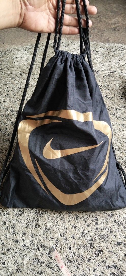 Nike Gymsack Drawstring Backpack Black Gold BA4656 (Category: Backpacks) located in Paranaque City. Submitted by michael-08 (Listing ID 1468752298, Image 2). Description: - Brand: Nike - Color: Black with metallic gold graphic - Material: 100% polyester (lightweight and durable) - Condition: Clean, tag intact - Ideal for: Gym, school, or casual daily trips - Care: Spot clean with a damp cloth only WALA PO ISSUE GOOD CONDITION WALA PO BASAK ANG PR