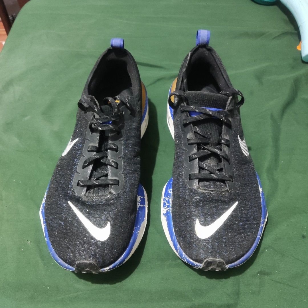 Nike Invincible Run 3 Black Blue Yellow (Category: Sneakers) located in San Mateo. Submitted by sweetys_closet (Listing ID 1468798797, Image 3). Description: Nike Invincible Run 3 running shoes. Black upper with white swoosh branding, accented with striking blue and yellow details on the heel and midsole. Thick cushioning for daily miles. Shows noticeable scuffs and paint chipping along the blue foam midsole section. Laces intact, soles have norm