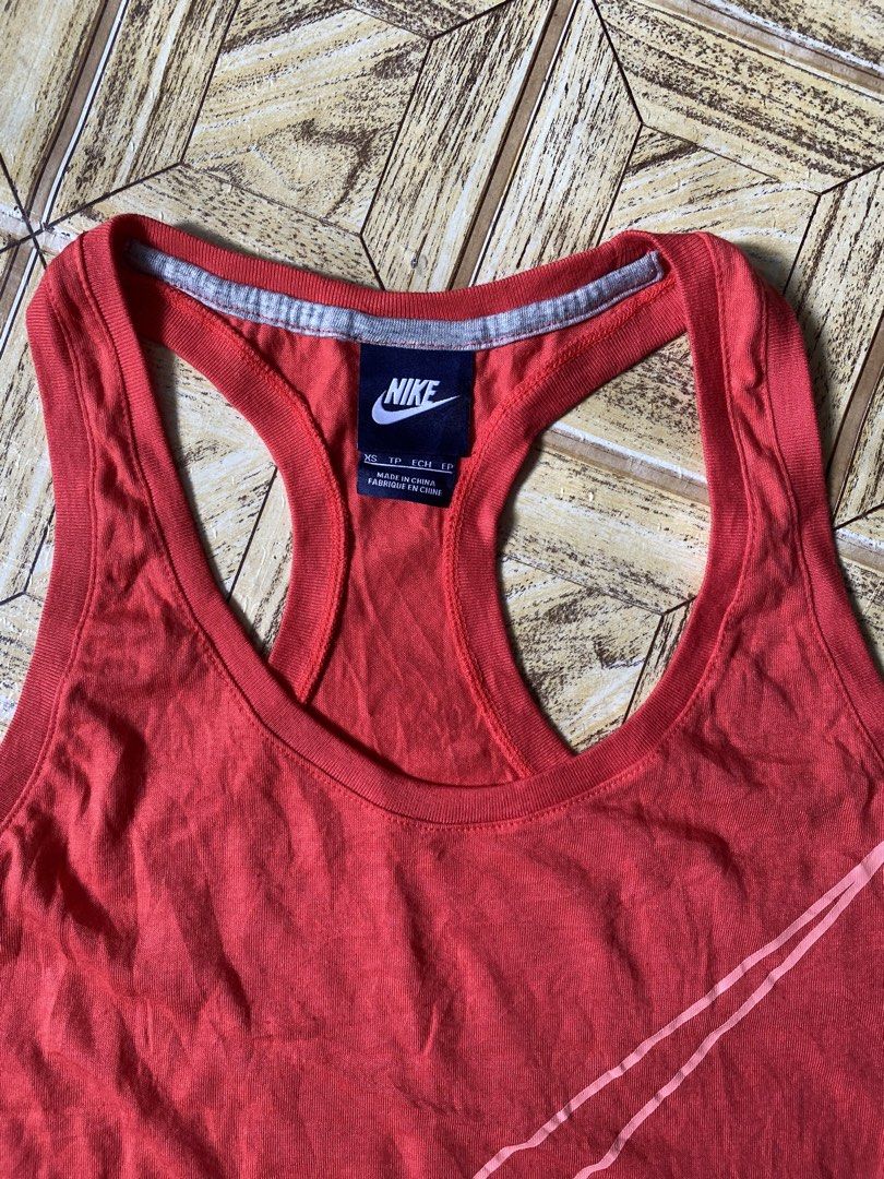 Nike Red Racerback Tank Top (Category: Activewear) located in Manila. Submitted by tygaangub1096 (Listing ID 1468883478, Image 2). Description: - Brand: Nike - Style: Racerback tank top with classic scoop neckline - Color: Bright red with grey contrast trim - Design: Large pink outline swoosh logo on the front - Size: XS - Details: Made in China, includes fabric care tag with product code 642775-647 - Condition: Excellent - Add shipping fee .