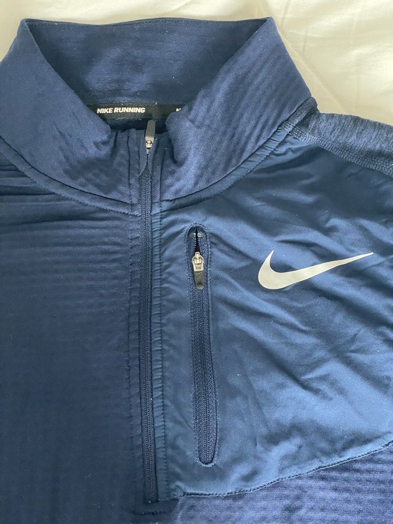 Nike Running Dri-Fit Navy Blue Quarter Zip Pullover (Category: Coats, Jackets and Outerwear) located in Angono. Submitted by marketplacesellerph610 (Listing ID 1468744675, Image 2). Description: - Brand: Nike Running - Style: Quarter zip pullover - Color: Navy blue - Size: Large (Made in Thailand) - Material: Dri-fit with textured waffle grid interior - Features: Small upper left chest zip pocket with reflective Swoosh logo, inner collar taping -