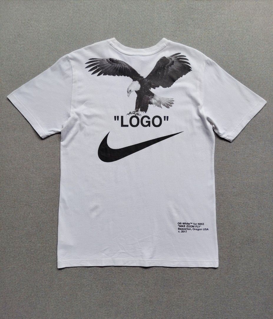 Nike x Off White NRG Shirt (Category: Tshirts & Polo Shirts ) located in Taguig. Submitted by _theroom.ph (Listing ID 1468752259, Image 1). Description: - Brand: Nike x Off-White - Color: White - Size: Medium (Made in China) - Front: Tuxedo & bow tie illustration with partial Swoosh - Back: Large bald eagle graphic, 'LOGO' text, and Nike Swoosh - Lower Back: Off-White for Nike Beaverton, Oregon USA text with c. 2017 date - Condition: Brand new / 