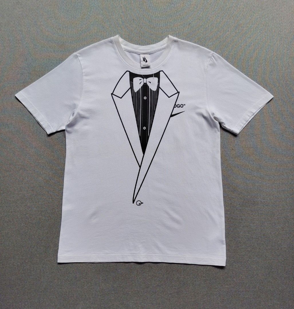 Nike x Off White NRG Shirt (Category: Tshirts & Polo Shirts ) located in Taguig. Submitted by _theroom.ph (Listing ID 1468752259, Image 2). Description: - Brand: Nike x Off-White - Color: White - Size: Medium (Made in China) - Front: Tuxedo & bow tie illustration with partial Swoosh - Back: Large bald eagle graphic, 'LOGO' text, and Nike Swoosh - Lower Back: Off-White for Nike Beaverton, Oregon USA text with c. 2017 date - Condition: Brand new / 
