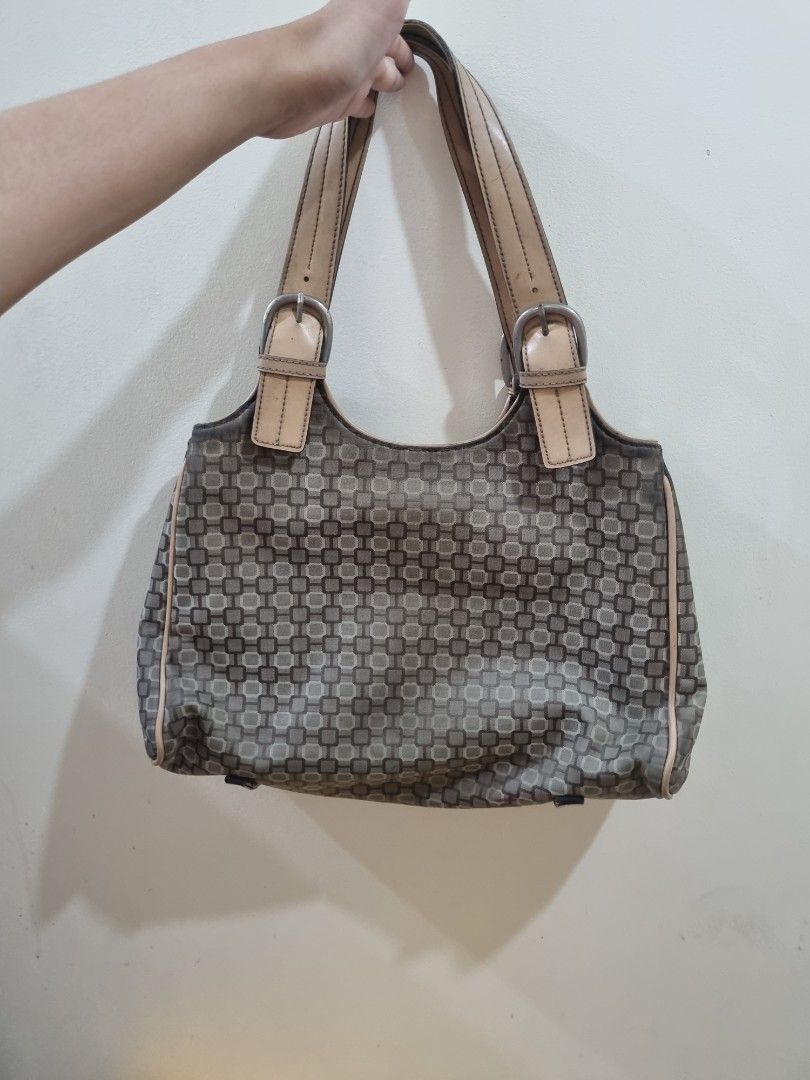 Nine West Monogram Pattern Shoulder Bag with Buckle Straps (Category: Shoulder Bags) located in Quezon City. Submitted by gabdclutz (Listing ID 1468838805, Image 2). Description: - Brand: Nine West - Design: Brown and tan geometric print with light tan leather trim - Straps: Double shoulder straps with stylish buckle details - Closure: Magnetic snap closure - Interior: Light fabric lining with zip pocket, slip pockets, and card slots - Flaw: Noti