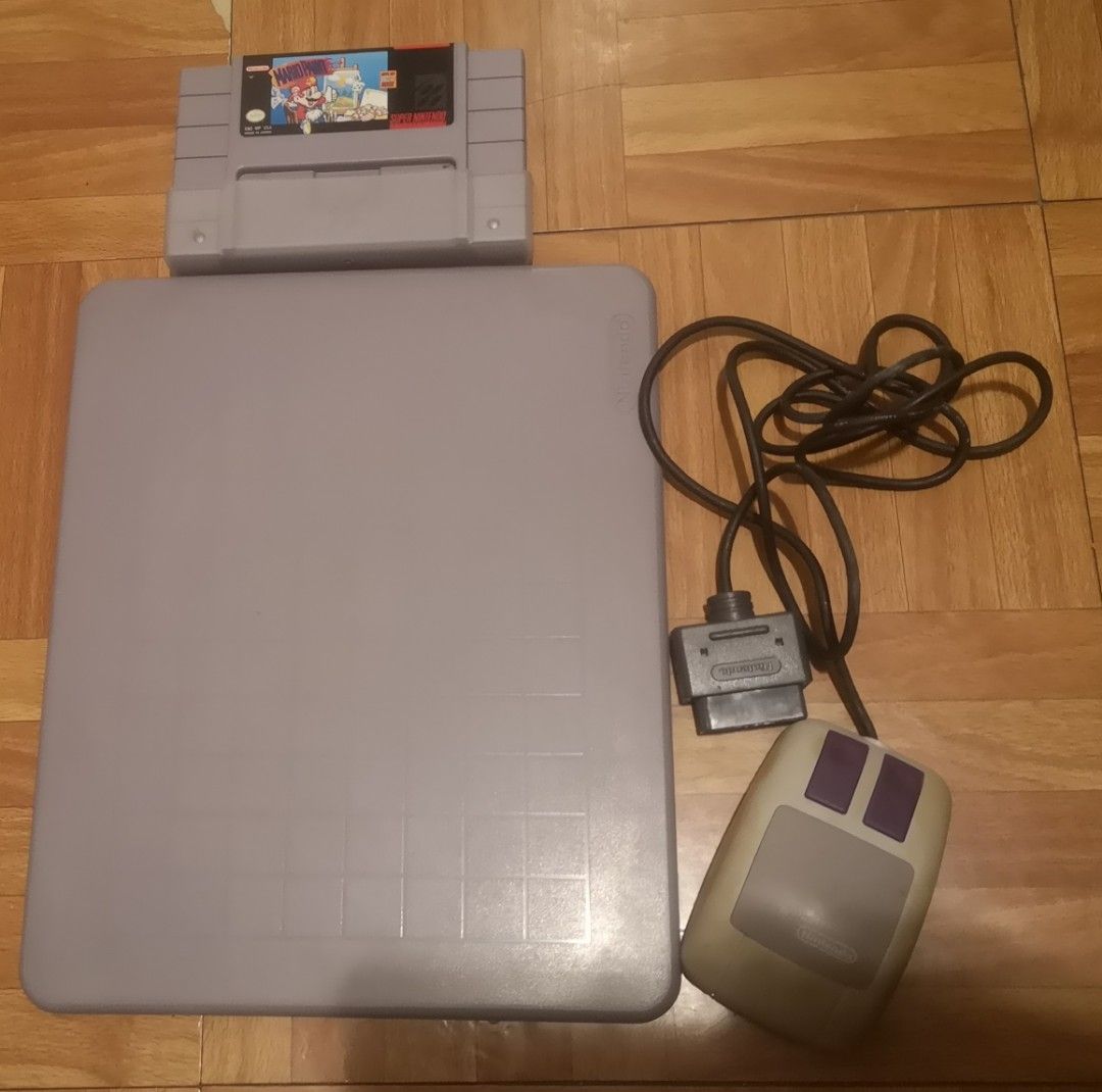 Nintendo Super NES SNES Mario Paint Mouse and Pad (Category: Nintendo) located in Quezon City. Submitted by dhanie.barican (Listing ID 1468846596, Image 3). Description: - Authentic Super Nintendo Mario Paint bundle for retro gaming fans - Includes original SNES game cartridge and official SNES mouse - Comes with plastic mouse pad, instruction booklet, and promotional paper insert - Note: Mouse plastic has some natural yellowing from age - Comple
