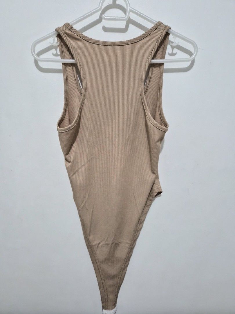 Nude ribbed racerback bodysuit (Category: Sleeveless) located in Mandaluyong City. Submitted by joyce1593 (Listing ID 1468818094, Image 2). Description: - Color: Neutral beige (goes with everything) - Style: Sleeveless, racerback, scoop neckline - Fabric: Ribbed, stretchy, and comfortable - Fit: Form-fitting with convenient bottom snap closure - Perfect for: Everyday layering under jeans or skirts.