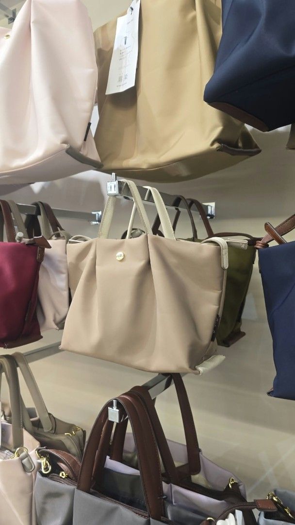 Nylon Tote Bag with Gold Button Accent (Category: Tote Bags) located in Manila. Submitted by frdyn (Listing ID 1468860608, Image 2). Description: - Colors: Neutral beige and olive green - Design: Stylish ruched front panel with gold hardware button closure - Details: Double carry handles with contrast trim - Practicality: Lightweight, easy to fold, pack, and carry - Capacity: Roomy interior, perfect for daily essentials - Condition: Brand new wit