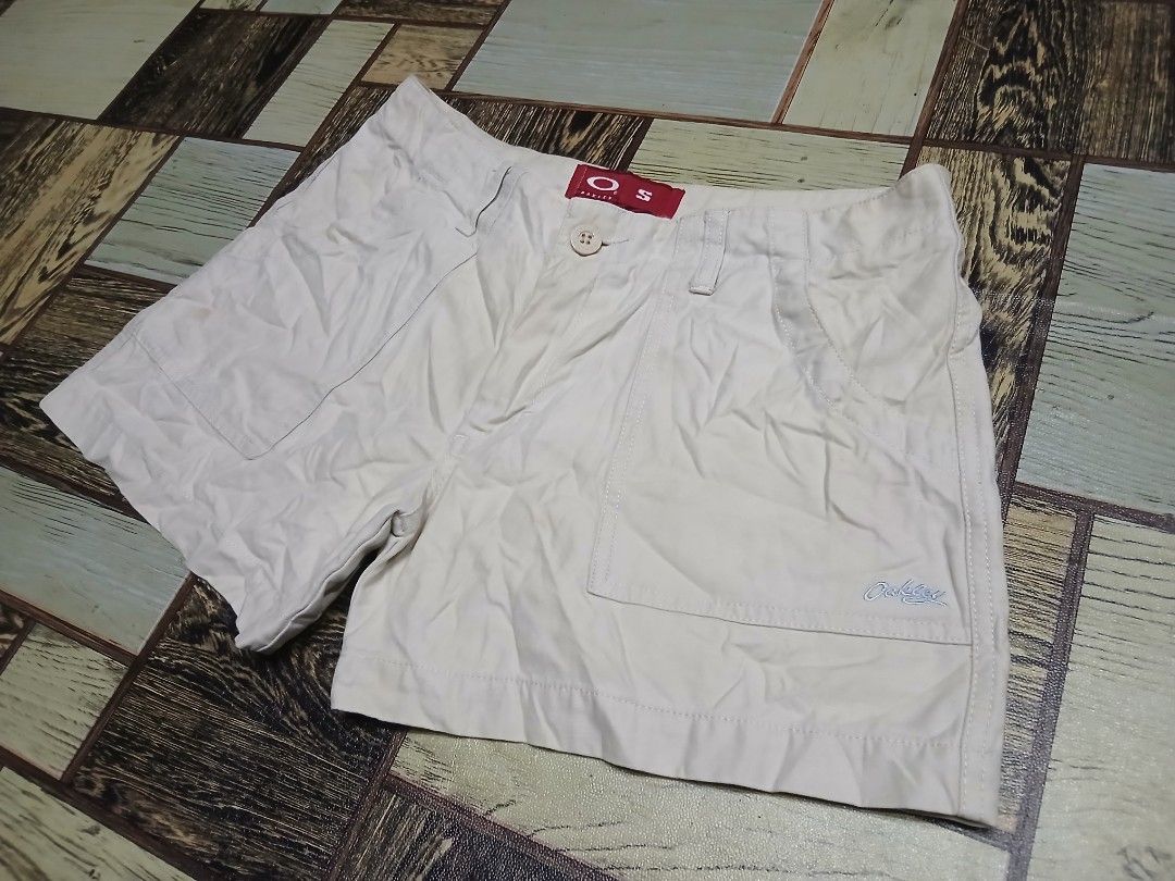 Oakley Beige Shorts Size S (Category: Shorts) located in Caloocan City. Submitted by youngmoon_51e2c6 (Listing ID 1468792917, Image 1). Description: - Brand: Oakley - Color: Beige - Size: Small (S) - Style: Classic utility shorts with button closure and belt loops - Details: Front patch pockets, embroidered Oakley logo near the hem, red brand label inside, and small red tag on the back pocket - Material: 100% Cotton - Origin: Made in Hong Kong.