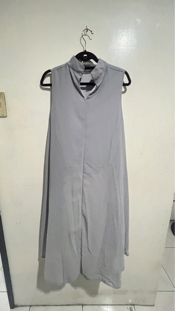 Office Blouse Sleeveless (Category: Dresses) located in Cabuyao City. Submitted by calmstorm.0108 (Listing ID 1468836134, Image 2). Description: - Colour: Grey - Style: Sleeveless dress with mock collar - Design: Front center slit and layered high-low hem with flowing back panels - Material: Lightweight and comfortable - Versatility: Easy to style with boots or heels for day-to-night wear.