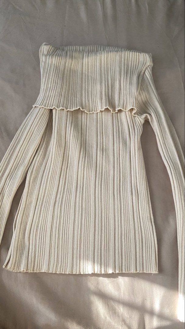 Off-shoulder ribbed knit sweater cream top (Category: Longsleeves) located in Manila. Submitted by rumyewn (Listing ID 1468790699, Image 2). Description: - Color: Cream - Style: Folded off-shoulder neckline with long sleeves and asymmetrical hem - Texture: Ribbed knit with soft stretch material - Versatility: Great basic for layering or wearing solo in cooler weather - Pairing: Matches well with both trousers and skirts.