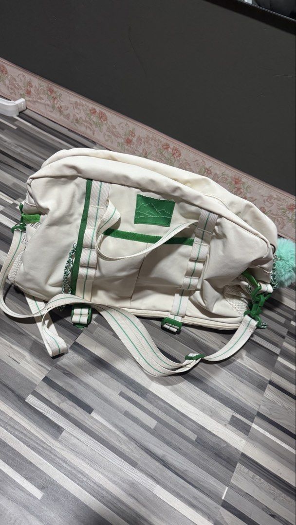 Off-white and green canvas duffel gym bag (Category: Shoulder Bags) located in Manila. Submitted by strk.24 (Listing ID 1468769400, Image 1). Description: - Color: Off-white canvas with bright green accents and webbing straps - Storage: Main zipper closure and convenient mesh side pockets - Details: Mountain embroidered patch, green trim, and a fluffy pom-pom charm - Versatility: Includes a detachable long shoulder strap for easy carrying - Condi