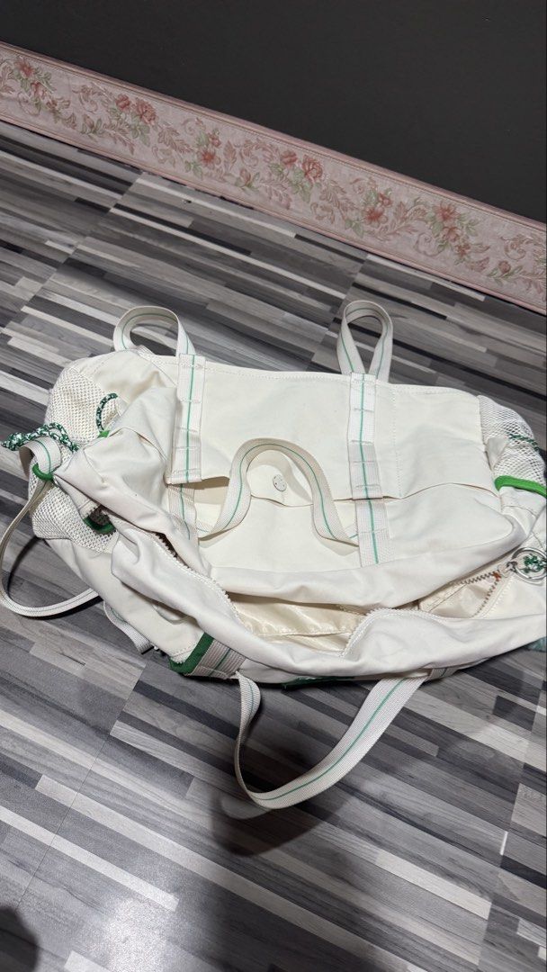 Off-white and green canvas duffel gym bag (Category: Shoulder Bags) located in Manila. Submitted by strk.24 (Listing ID 1468769400, Image 2). Description: - Color: Off-white canvas with bright green accents and webbing straps - Storage: Main zipper closure and convenient mesh side pockets - Details: Mountain embroidered patch, green trim, and a fluffy pom-pom charm - Versatility: Includes a detachable long shoulder strap for easy carrying - Condi
