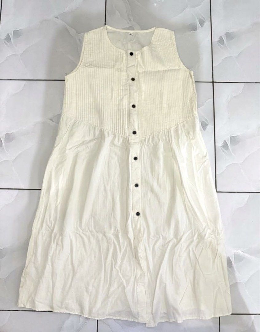 Off-white Sleeveless Button-down Midi Dress Size S (Category: Dresses) located in Cagayan de Oro. Submitted by ninaaam (Listing ID 1468766455, Image 1). Description: - Color: Off-white - Size: L - Style: Sleeveless long dress with scoop neckline and front button closure - Design details: Pleated chest panel, relaxed lower skirt, and contrasting dark buttons - Condition: Good, but has wrinkles from storage and a faint reddish stain near the hem (s