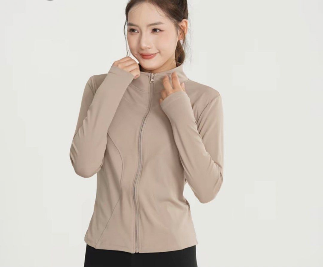 Omcore jacket (Category: Coats, Jackets and Outerwear) located in Cheras. Submitted by iqa___ (Listing ID 1468782832, Image 2). Description: - Color: Taupe - Style: Athletic zip-up jacket with a fitted silhouette - Features: Stand-up collar, full front zipper, and thumbholes at the cuffs - Details: Flattering curved seam lines along the torso - Material: Lightweight and stretchy activewear fabric - Condition: Brand new / Excellent (ready to wear)