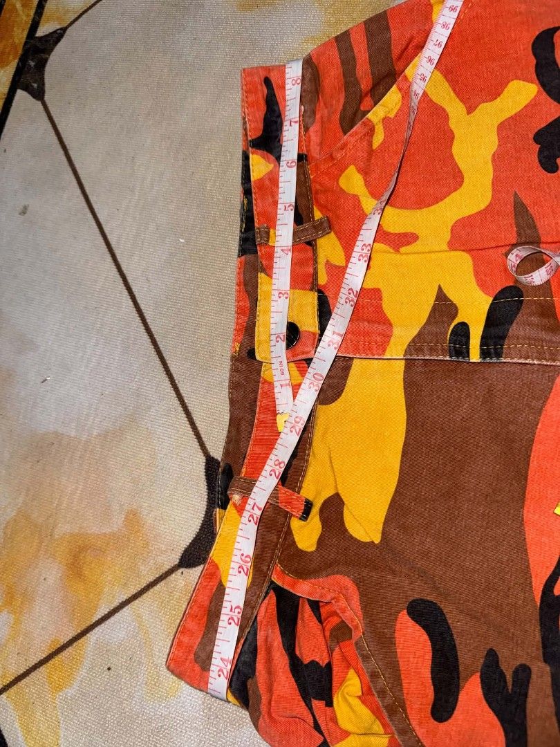 Orange Camo Cargo Pants Utility Joggers (Category: Joggers) located in Caloocan City. Submitted by mylove326 (Listing ID 1468794121, Image 3). Description: - Vibrant orange camo print (orange, yellow, brown, and black) - fit with secure button and zipper closure - Practical utility pockets on both sides - Trendy elastic cuffs at the ankles - Made from durable, sturdy cotton material - Ultimate streetwear statement piece - Please refer to the pict