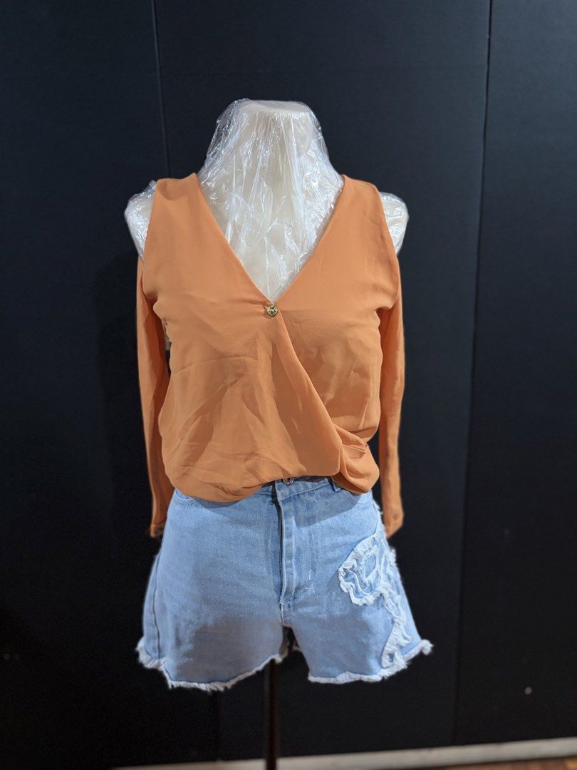 Orange Cold Shoulder Wrap Blouse (Category: Blouses) located in Manila. Submitted by everydaymeanseveryday (Listing ID 1468865371, Image 1). Description: - Color: Vibrant Orange - Style: Cold-shoulder long-sleeve blouse with V-neck wrap front - Details: Features a single decorative center button - Fabric: Lightweight with a relaxed, flowy drape - Condition: Clean, excellent, and ready to wear - Perfect for: Casual day outs, pairs great with denim