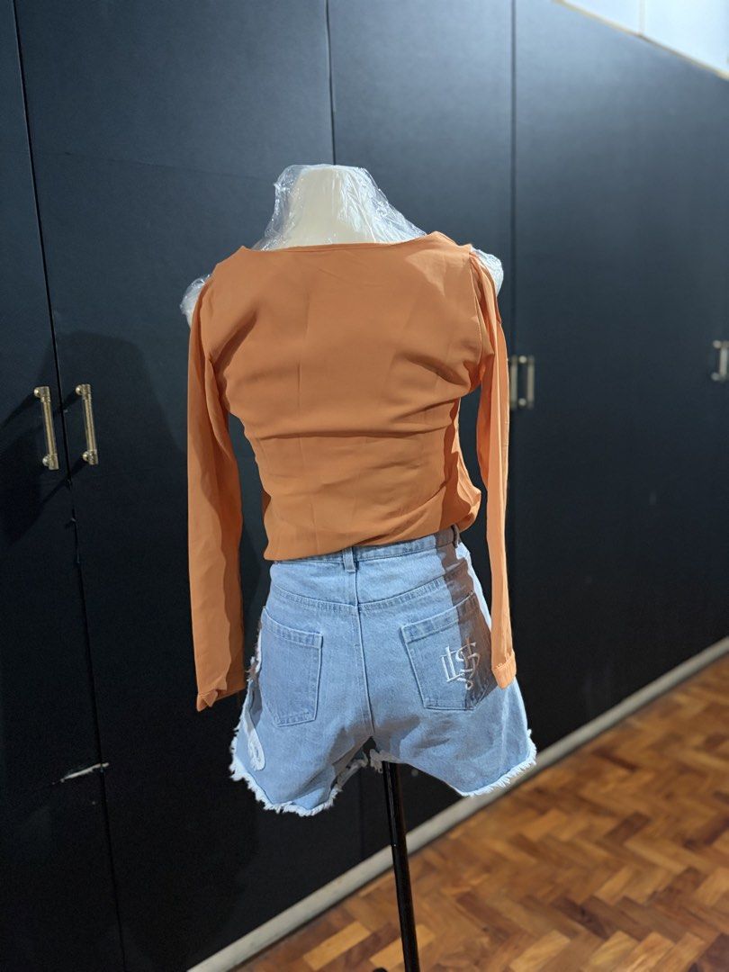 Orange Cold Shoulder Wrap Blouse (Category: Blouses) located in Manila. Submitted by everydaymeanseveryday (Listing ID 1468865371, Image 3). Description: - Color: Vibrant Orange - Style: Cold-shoulder long-sleeve blouse with V-neck wrap front - Details: Features a single decorative center button - Fabric: Lightweight with a relaxed, flowy drape - Condition: Clean, excellent, and ready to wear - Perfect for: Casual day outs, pairs great with denim