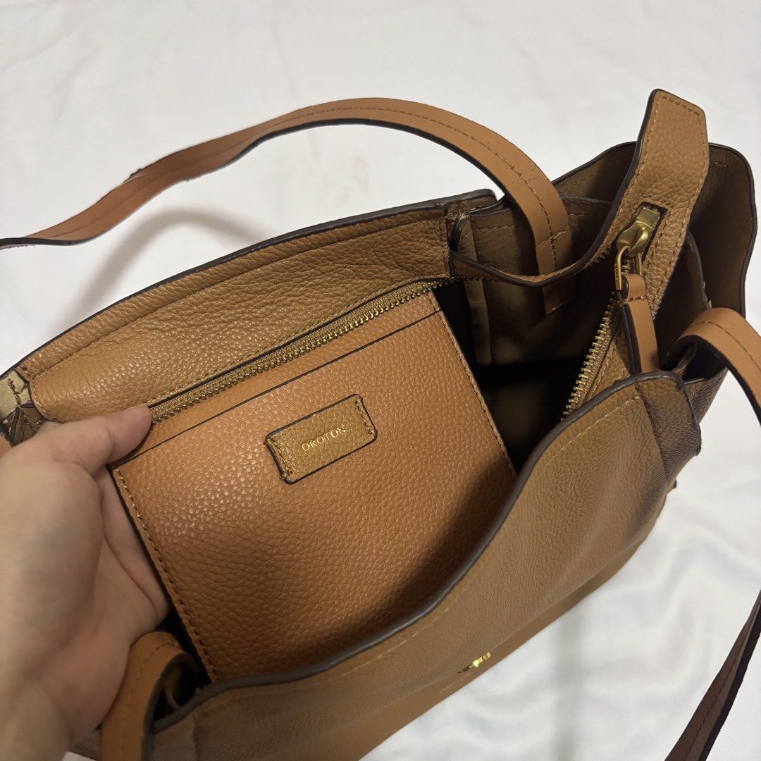 Oroton Tan Pebbled Leather Tote Bag (Category: Luxury Bags & Wallets) located in Imus. Submitted by wear.arca (Listing ID 1468826041, Image 3). Description: - Brand: Oroton - Material: Tan pebbled leather with gold-tone hardware - Closure: Front buckle strap - Straps: Twin shoulder straps - Flaws: Noticeable scuffing on the handle edge and peeling along the inner lining trim (kindly check close-up photos before buying) - So spacious and body is s