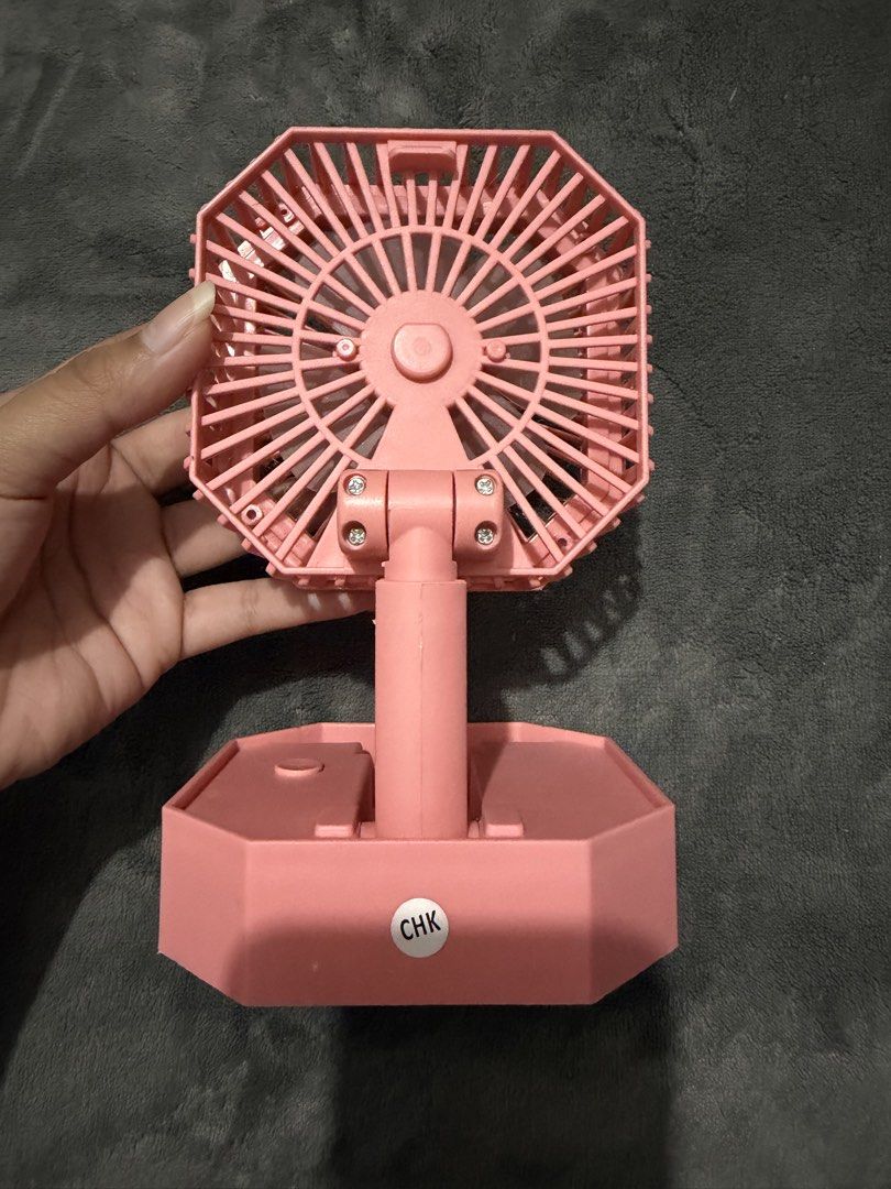 Pink portable folding desk fan with LED ring light (Category: Fans) located in Mandaluyong City. Submitted by josa_xox0i8 (Listing ID 1468747405, Image 3). Description: Compact and foldable mini desk fan with a built-in LED ring light. Great for personal cooling, makeup/selfie lighting, study tables, or bedside nightstands. Design: Octagonal frame, foldable base for easy storage and portability Features: Built-in LED light ring, rechargeable via 