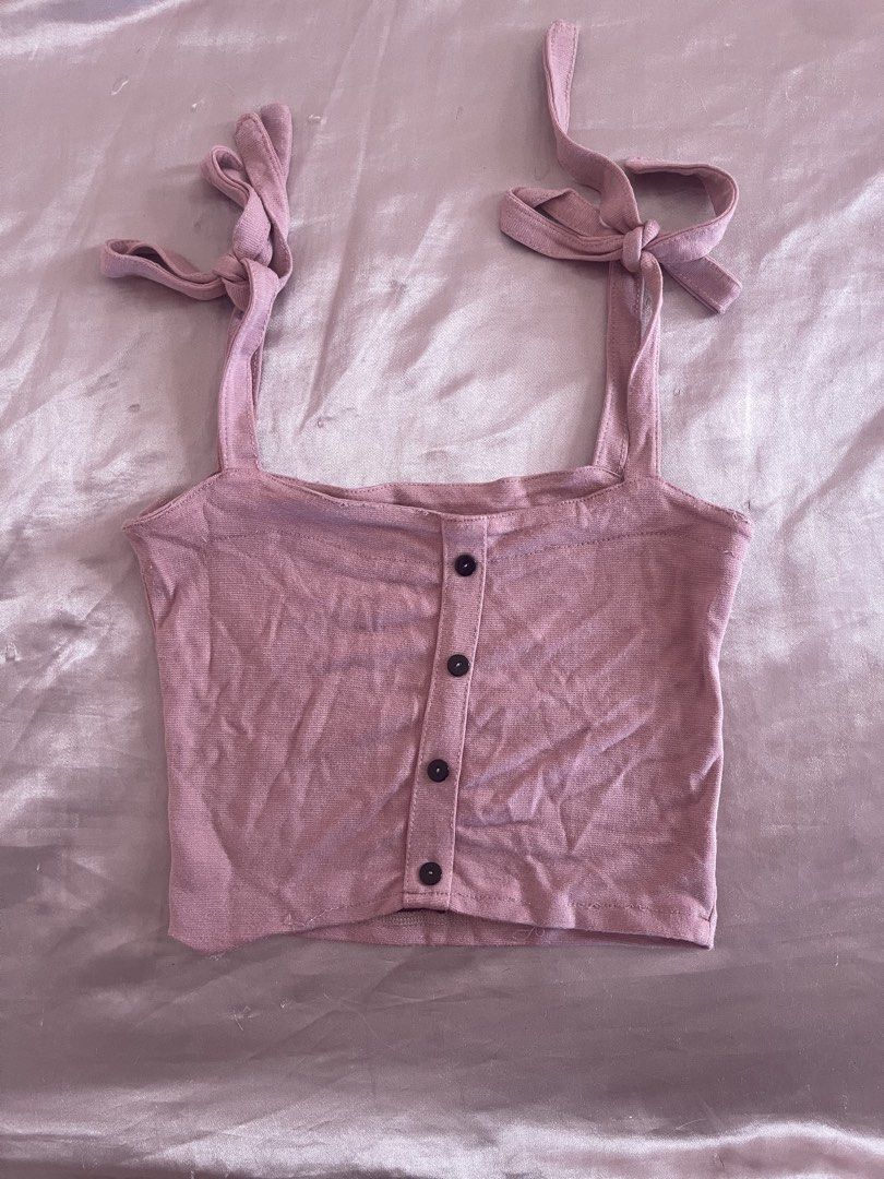 Pink Ribbed Crop Top with Button Front and Tie Straps (Category: Sleeveless) located in Manila. Submitted by lovedbymidge (Listing ID 1468868938, Image 1). Description: - Color: Pink - Style: Ribbed crop top with straight neckline - Details: Front button closure with 4 dark buttons - Straps: Adjustable self-tie shoulder straps - Fabric: Soft, lightweight knit - Condition: Clean and well-maintained - Perfect for: Warm weather or easy layering with