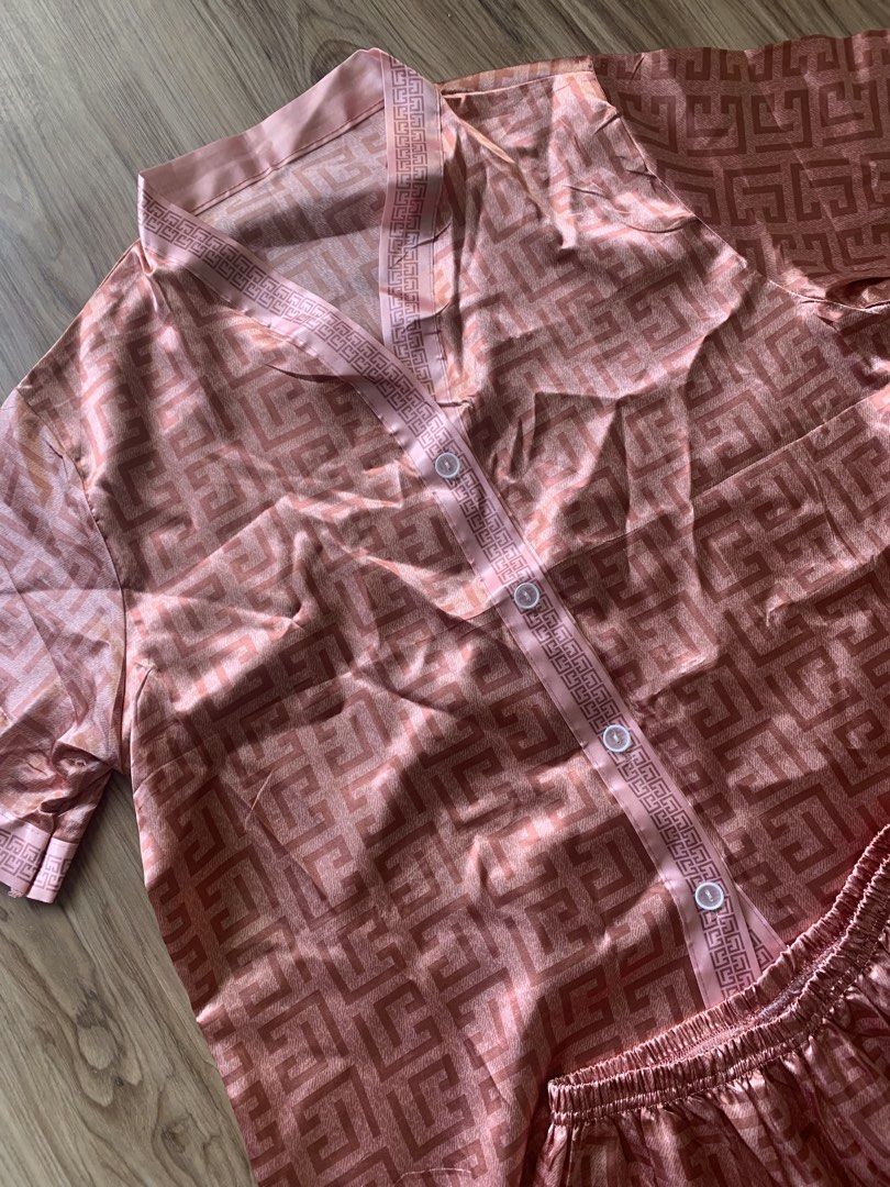 Pink Satin Geometric Pattern Short Sleeve Pajama Set (Category: Undergarments & Loungewear) located in Antipolo. Submitted by Sparkle111 (Listing ID 1468715673, Image 2). Description: - Pink satin pajama set featuring an all-over geometric pattern - Short sleeve button-down top with neat white buttons - Matching pants with a comfortable elastic waistband - Silky smooth, lightweight material - Perfect for sleeping or cozy days at home.