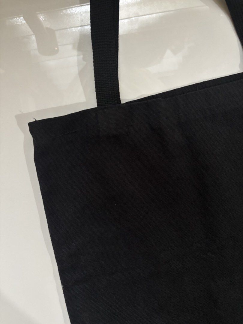 Plain Black Canvas Tote Bag Everyday Casual (Category: Tote Bags) located in Davao. Submitted by 553club (Listing ID 1468801233, Image 2). Description: - Color: Solid black - Material: Lightweight canvas, unlined interior - Design: Simple rectangular shape with sturdy shoulder straps - Features: Foldable and easy to stash in another bag - Best for: Daily errands, school, or grocery runs - Style: Minimalist design that matches any outfit.