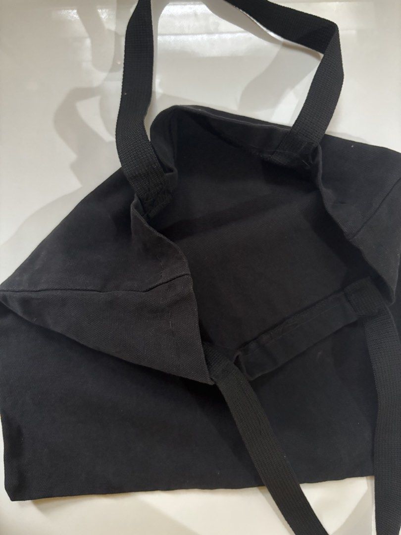 Plain Black Canvas Tote Bag Everyday Casual (Category: Tote Bags) located in Davao. Submitted by 553club (Listing ID 1468801233, Image 3). Description: - Color: Solid black - Material: Lightweight canvas, unlined interior - Design: Simple rectangular shape with sturdy shoulder straps - Features: Foldable and easy to stash in another bag - Best for: Daily errands, school, or grocery runs - Style: Minimalist design that matches any outfit.