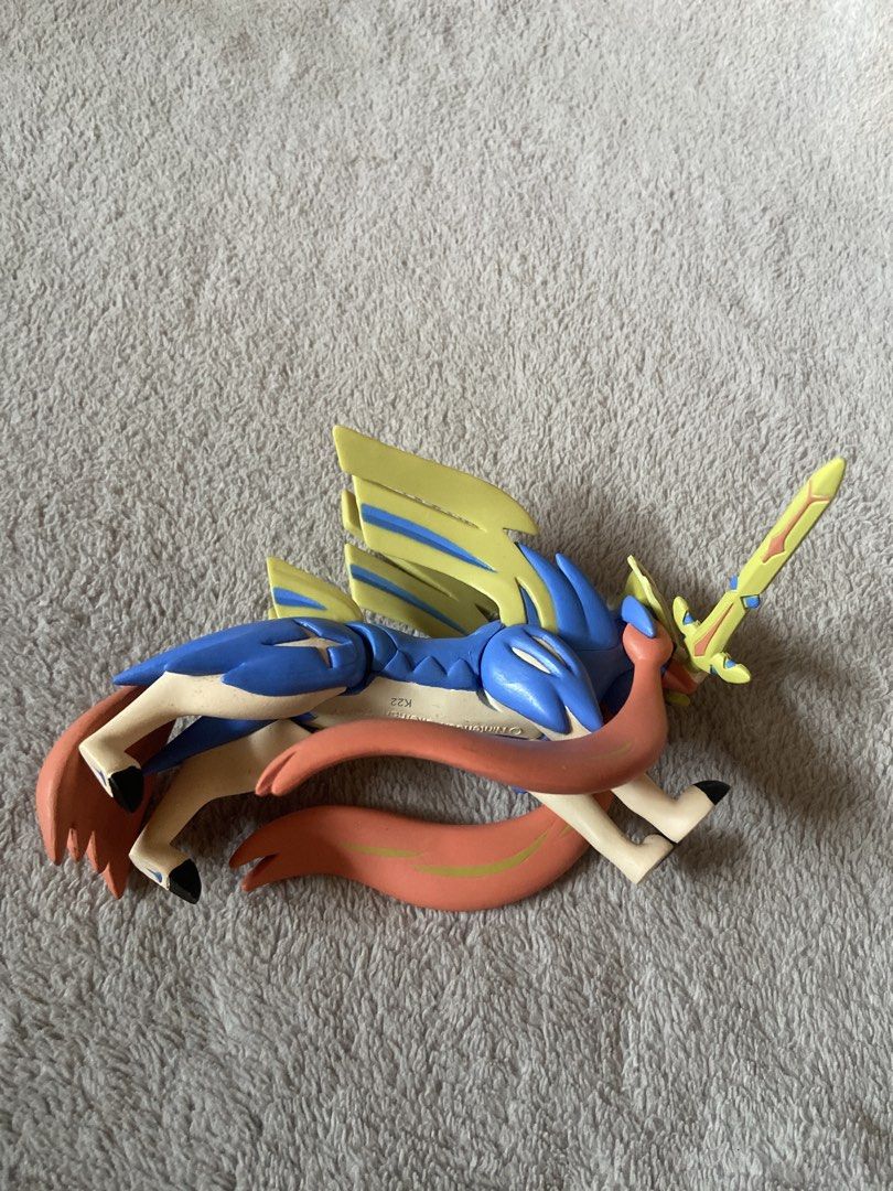 Pokémon Zacian Crowned Sword Tomy Figure (Category: Figurines & Statues) located in Davao. Submitted by mengsmixitems (Listing ID 1468715182, Image 2). Description: - Brand: Tomy (Official Nintendo stamp on underside) - Character: Zacian (Crowned Sword Form) - Colors: Blue and gold design - Condition: Stands well on display - Ideal for Pokémon collections.