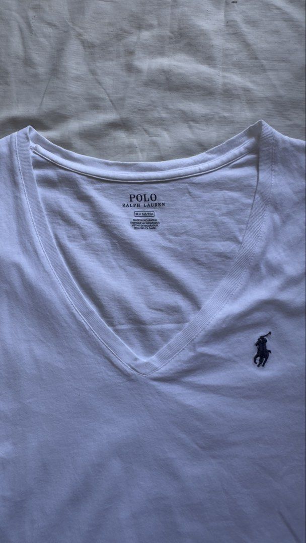 POLO RALPH LAUREN (Category: Shirts) located in Davao. Submitted by kelsocool (Listing ID 1468801157, Image 2). Description: Polo Ralph Lauren White V-Neck Tee Size: M Dimes (inch): 24 - length 18 - width 5.5 - sleeve color rate: 8.5/10 good condition issue - minor collar wear / light wash Description: Clean white Polo Ralph Lauren V-neck cotton tee with dark blue signature embroidered pony hit..