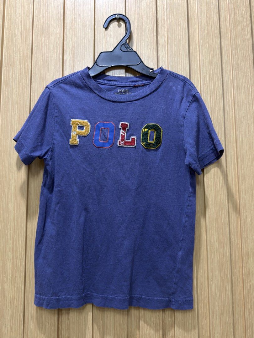 Polo Ralph Lauren Patchwork Logo Tee Size 4/5 110 (Category: Tshirts & Polo Shirts ) located in Bacoor. Submitted by preloved_with_love_ (Listing ID 1468870573, Image 1). Description: - Brand: Polo Ralph Lauren - Size: 4/4T (110) - Color: Purple with multicolored chenille letter patches (yellow, blue, red, green) - Design: Short sleeve, crew neck - Material: Soft and comfortable cotton - Condition: Excellent.