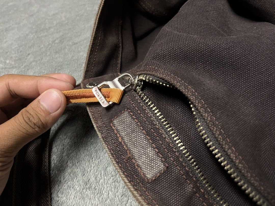 Porter-Yoshida & co.brown tote bag (Category: Luxury Bags & Wallets) located in Manila. Submitted by james23t (Listing ID 1468874629, Image 3). Description: Porter-Yoshida & Co. canvas stripe tote bag in brown, featuring a brown cotton canvas body, dual carry handles, a front woven “Porter” brand label, and distinctive horizontal multi-colored stripes (including a bold yellow stripe near the bottom and pink/white/black accents across the center).