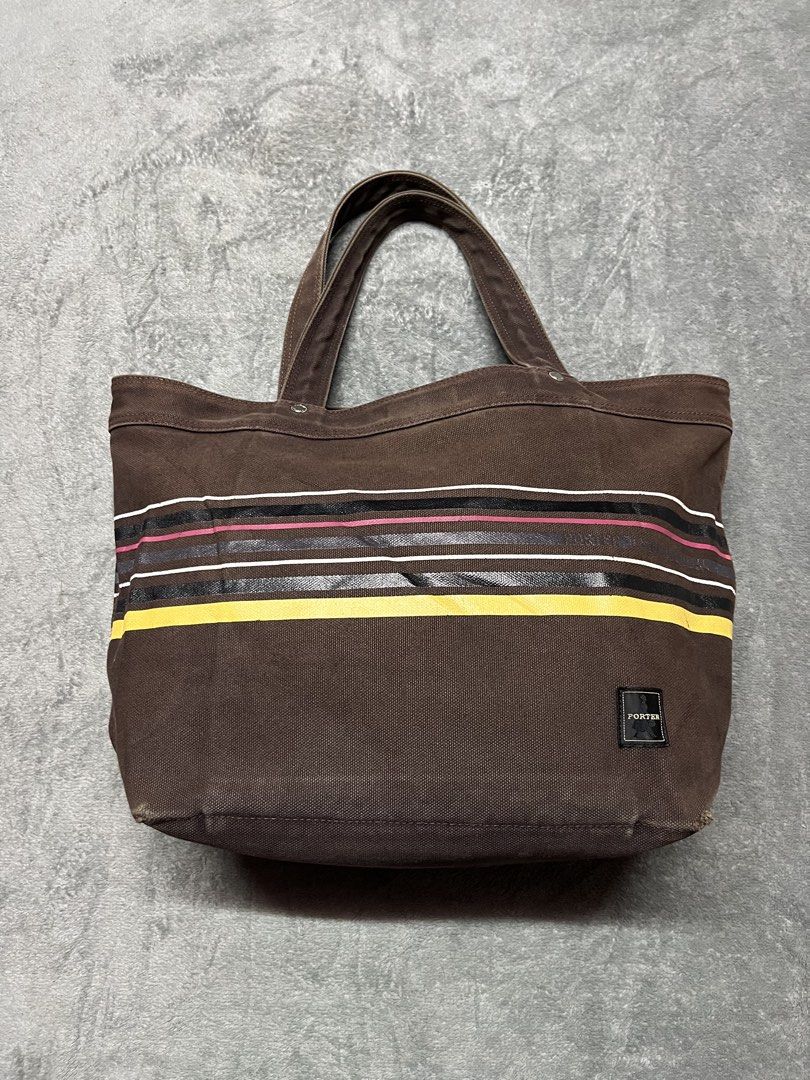 Porter-Yoshida & co.brown tote bag (Category: Luxury Bags & Wallets) located in Manila. Submitted by james23t (Listing ID 1468874629, Image 1). Description: Porter-Yoshida & Co. canvas stripe tote bag in brown, featuring a brown cotton canvas body, dual carry handles, a front woven “Porter” brand label, and distinctive horizontal multi-colored stripes (including a bold yellow stripe near the bottom and pink/white/black accents across the center).