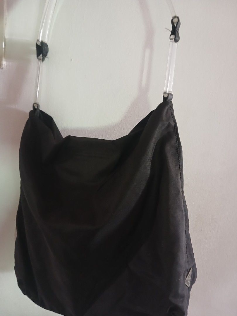 Prada Black Nylon Shoulder Bag with Clear Handles (Category: Luxury Bags & Wallets) located in Marikina City. Submitted by laila15 (Listing ID 1468922665, Image 1). Description: - Authentic black Prada shoulder bag made from signature lightweight nylon - Features stylish clear transparent handles secured with black leather tabs - Iconic silver-tone Prada triangle logo plaque on the side - Spacious, slouchy interior with secure zip closure - Condi