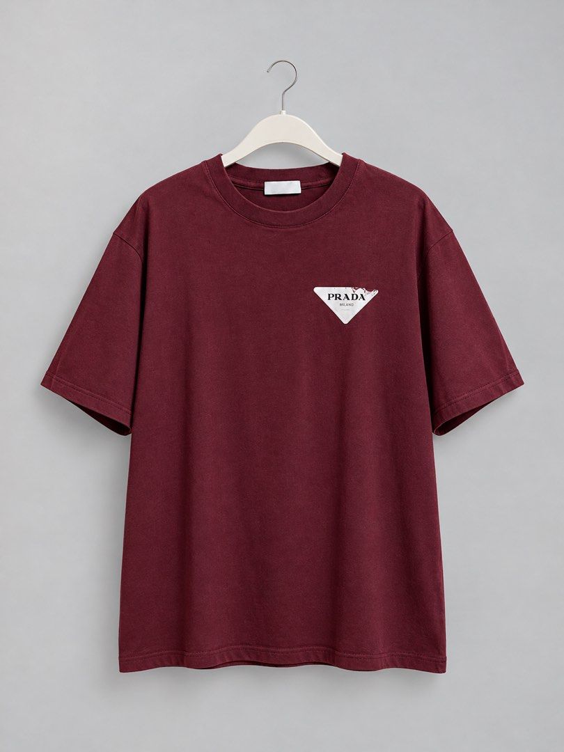 Prada Burgundy Triangle Logo T-Shirt Size M (Category: Shirts) located in Iloilo. Submitted by cloud.thrifts (Listing ID 1468802025, Image 1). Description: - Brand: Prada - Color: Burgundy - Material: 100% Cotton (Made in Italy) - Size: Medium (M) - Design: Short sleeves, crew neck, white triangular logo patch with distressed print - Condition: Excellent, comes with clean interior manufacturing and care tags.