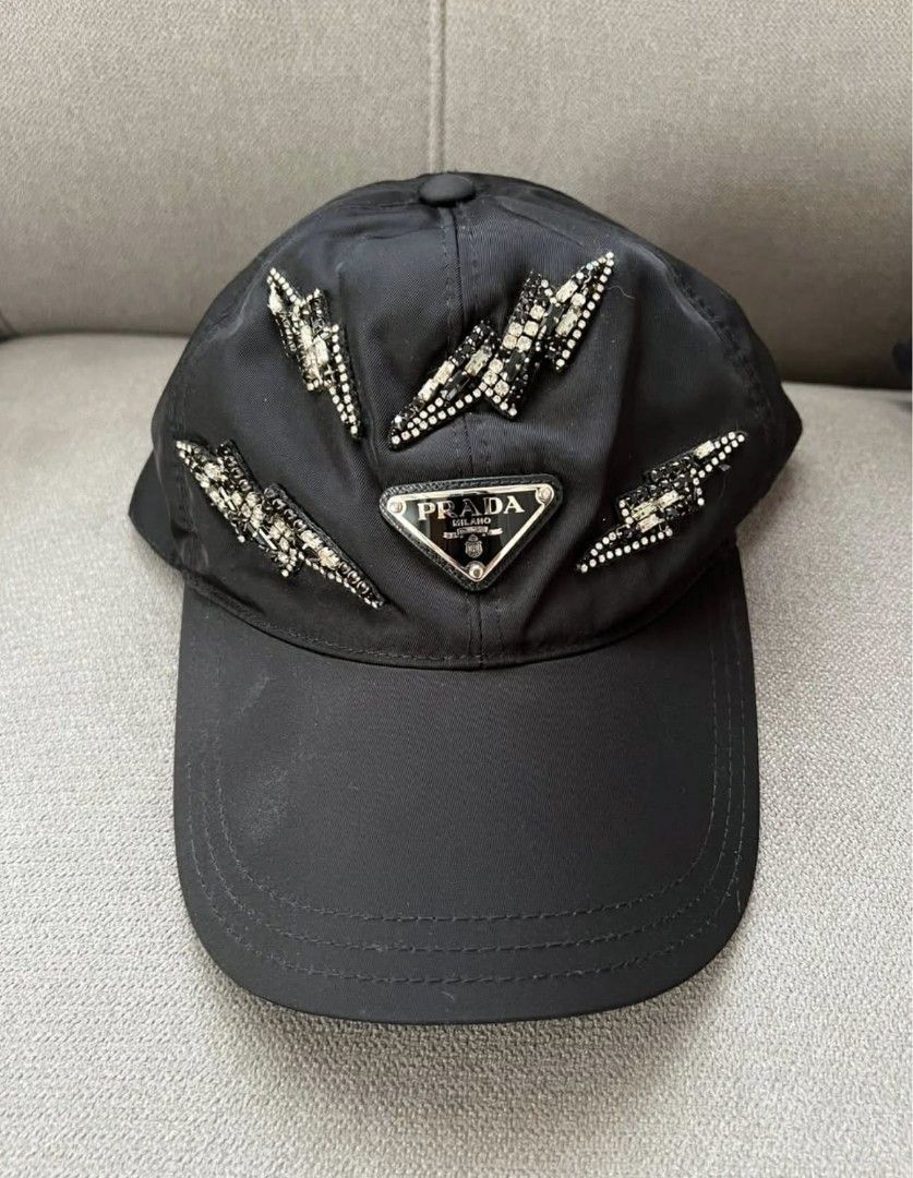 Prada Crystal Lightning Bolt Nylon Baseball Cap Black (Category: Caps & Hats) located in Manila. Submitted by supermom888 (Listing ID 1468782473, Image 1). Description: - Brand: Prada - Color: Classic Black - Material: Durable high-quality nylon - Logo: Iconic enameled metal triangle logo in front - Detailing: Eye-catching crystal-encrusted lightning bolt appliques - Fit: Adjustable back strap (fits most sizes) - Condition: Pristine / Like new - 